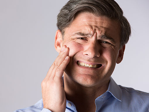 Man-with-Mouth-Pain | Pollock Advanced Dental Group family smiling together